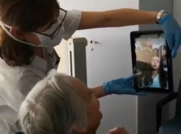 Una professional habilita la comunicació d'una usuària amb els seus familiars amb una tablet