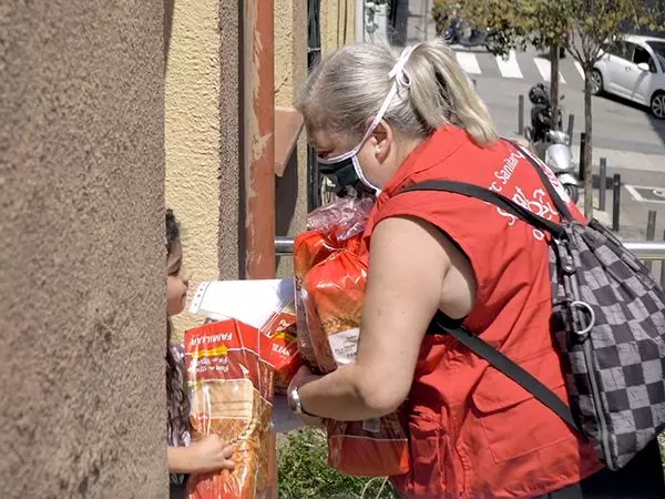 Una voluntària portant productes d'alimentació a una família usuària.